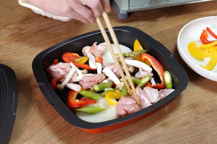 4-2 Xếp đùi gà và các loại rau lên chảo nướng. Về phần rau củ, bạn có thể thêm tùy thích hoặc dư ra nhé! Lần này mình dùng hành tây, ớt bột, măng tây và nấm shimeji để lên màu đẹp mắt.